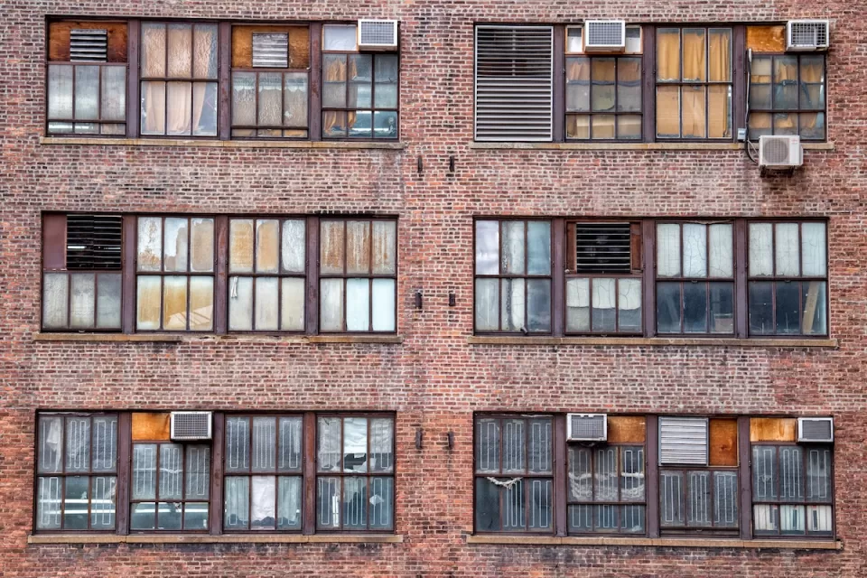 Manhattan brick apartments with AC units on windows.